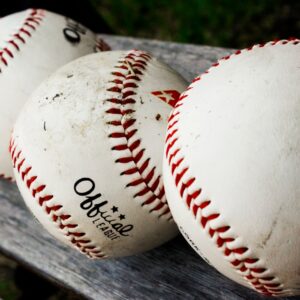 white and red baseball on black wooden table